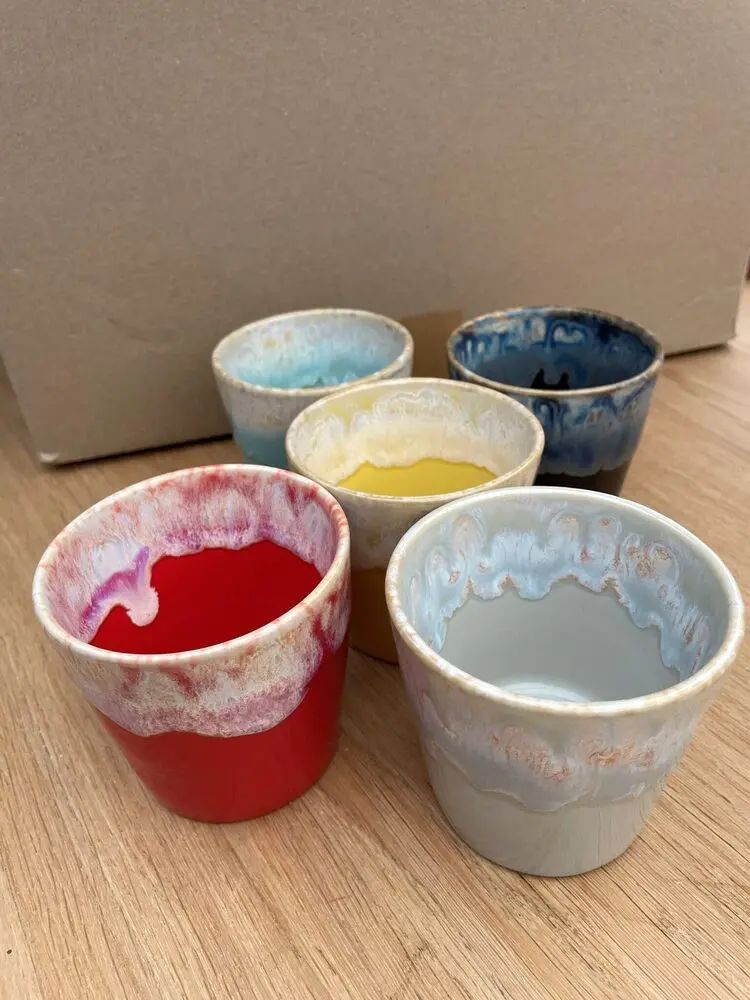 Vijf handgemaakte keramieken kopjes in rood, geel, blauw en grijsblauw